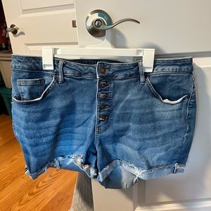Plus size jean shorts with frayed hem and button closure